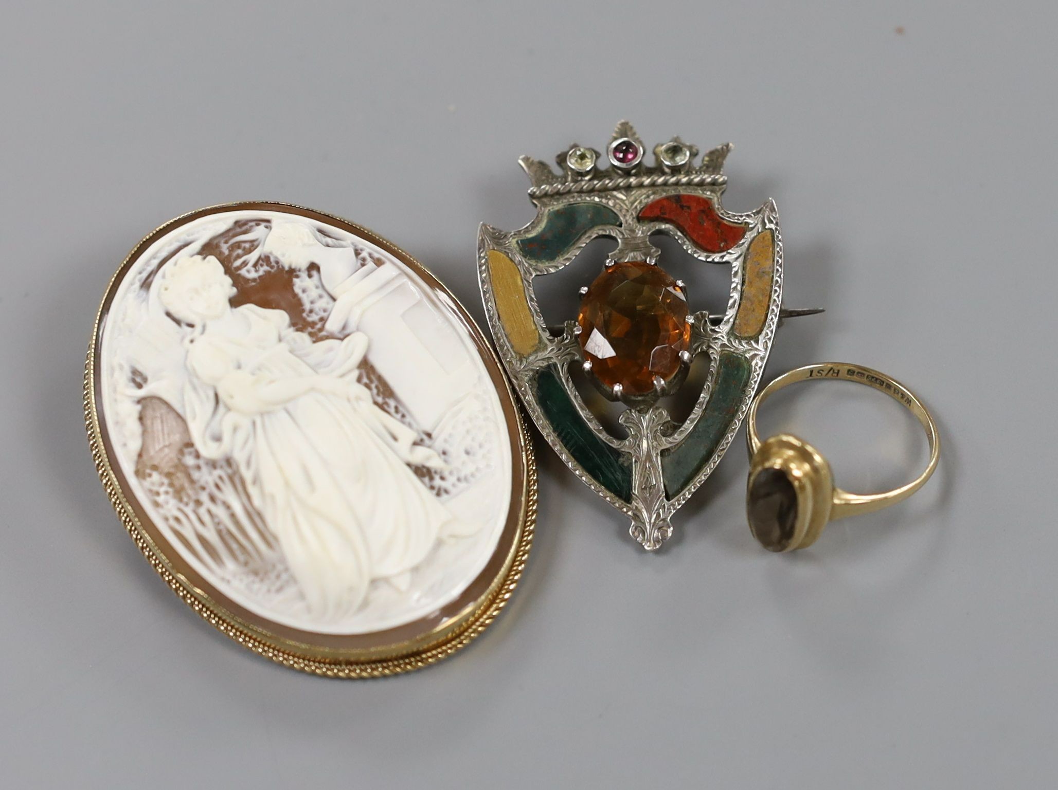 A modern 9ct gold mounted oval cameo shell brooch, 53mm, a 9ct gold and gem set ring and a white metal, gem and Scottish hardstone set shield shaped brooch